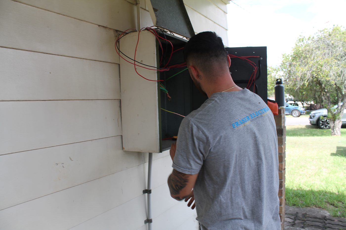 Fraser Electrical technician at an outdoor switchboard